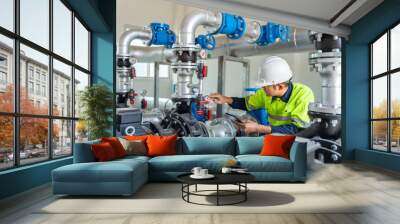 Asian worker at water supply stations inspect and maintain condenser equipment. Pumps in power substations for supplying clean water in industrial estates. Industrial plumbing. Wall mural