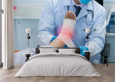 Close-up hand of orthopedic doctor wear medical gloves  Of Doctor Hand Tying Bandage On The Leg Of Patient In Clinic, osteophytes and heel, inflammation Wall mural