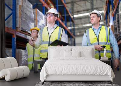 Worker in warehouse hold tablet check list perform inventory stock check goods boxes on the storage steel racking for annual report Wall mural