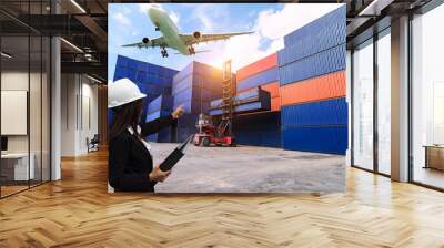 The engineer working with container Cargo freight ship in shipyard at dusk for Logistic Import Export background Wall mural