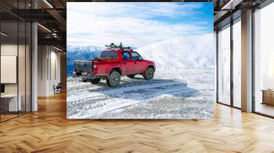 Red pickup truck on road, Beautiful winter road under snow mountains New Zealand. Wall mural