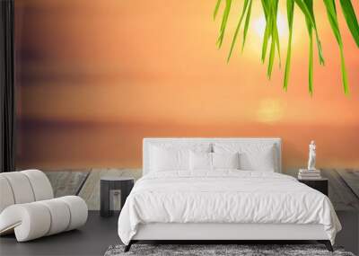 Blur beautiful tropical sunset beach with bokeh sun light wave on copy space empty old wood table abstract background. Wall mural