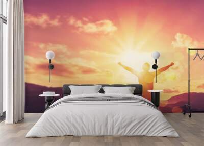 Copy space of man rise hand up on top of mountain and sunset sky abstract background. Wall mural