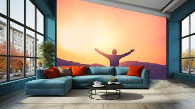 Copy space of man rise hand up on top of mountain and sunset sky abstract background. Wall mural