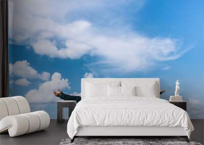 Copy space of silhouette man rising hands with sun light and blue sky white clouds abstract background. Wall mural