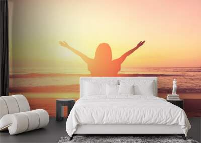 Copy space of woman rise hand up on sunset sky at beach and island background. Wall mural