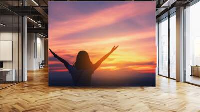 copy space of woman rise hand up on top of mountain and sunset sky abstract background. Wall mural