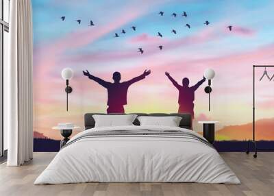 Couple rising hands and birds flying on sunset sky at nature field abstract background. Freedom feel good and travel adventure concept. Wall mural