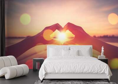 Female hands heart shape on nature bokeh sun light flare wave and blur tropical beach abstract background. Wall mural