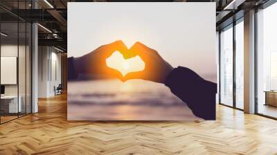 Female hands heart shape on nature bokeh sun light flare wave and blur tropical beach abstract background. Wall mural