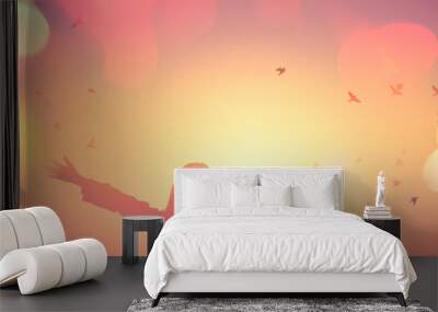 Freedom and feel good concept. Copy space of silhouette woman rising hands on sunset sky background. Wall mural