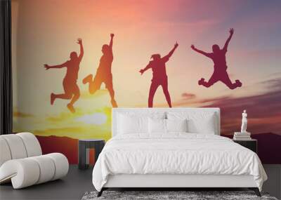 Silhouette friends jump and birds fly on sunset sky at top of mountain abstract background. Wall mural