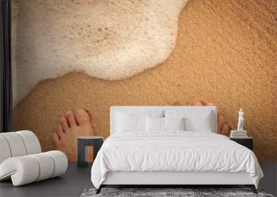 Top view of foots on sand beach with smooth wave Wall mural