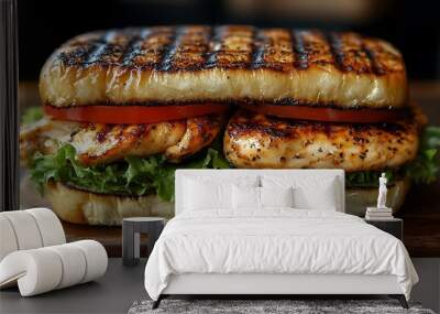 Close-up of a grilled chicken sandwich with lettuce and tomato on a wooden cutting board. Wall mural