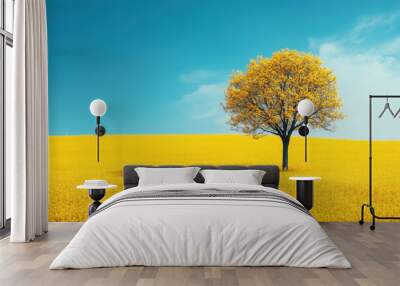 Lone tree in vibrant yellow flower field under a clear blue sky, capturing the serene beauty of nature and the tranquility of an open landscape. Wall mural