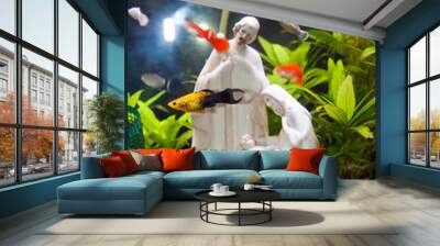 A white pottery figurine representing the Nativity scene placed in a tropical aquarium. Wall mural