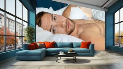 Shirtless sexy hunky man with beard lies naked in bed Wall mural