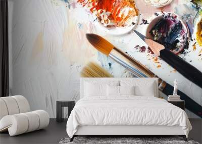 A closeup view of a vibrant and creative workspace featuring a variety of colorful paint brushes an assortment of paint colors on a palette and a messy abstract background Wall mural