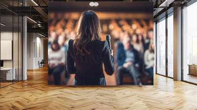 a woman speaking in front of crowd people bokeh style background Wall mural