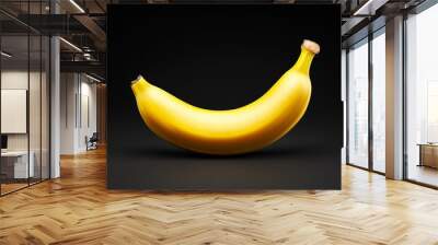 A banana is shown on a black background Wall mural