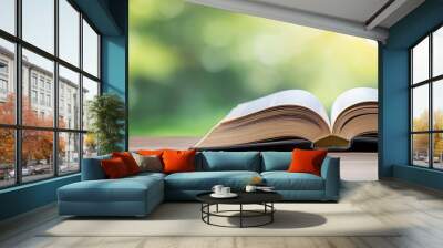 A book is open on a table with a green background Wall mural