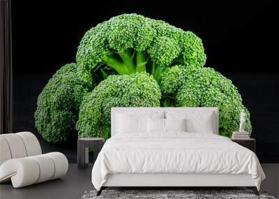 A bunch of broccoli is sitting on a black counter Wall mural