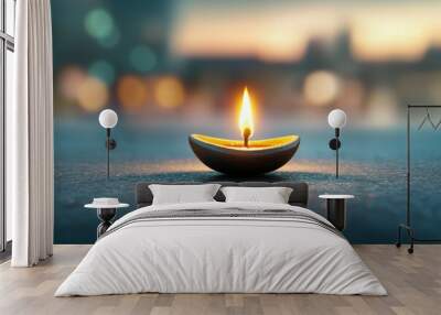 A candle is lit in a small bowl on a dark surface Wall mural