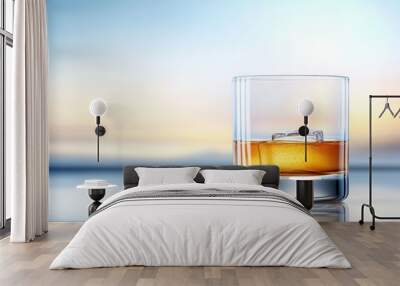 A glass of whiskey is sitting on a table with a blue sky in the background Wall mural