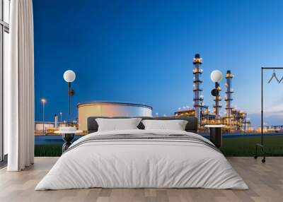 A large industrial plant with a large white tank in the foreground Wall mural