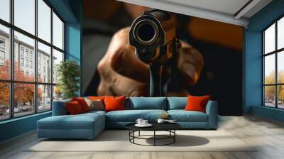 A man is holding a gun and pointing it at the camera, armed robber or dangerous burglar Wall mural