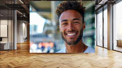 A man with a beard and dark hair is smiling and looking at the camera. Football fans or spectators Wall mural