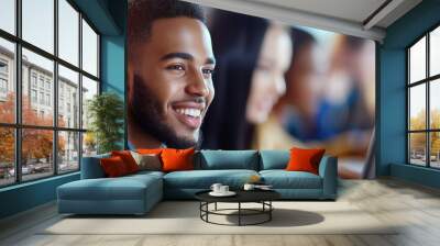 A man with a beard is smiling at a computer screen Wall mural