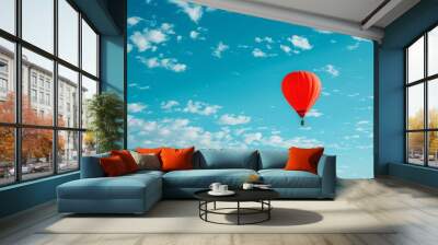 A red hot air balloon is flying high in the sky above a blue sky Wall mural