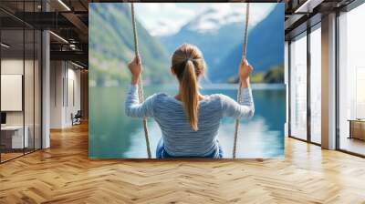 A woman is swinging on a rope over a lake Wall mural