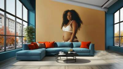 A woman with a large belly is wearing a white bikini top and bikini bottoms Wall mural