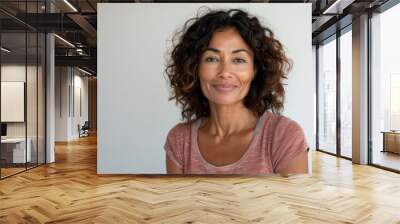 A woman with brown hair and a pink shirt is smiling Wall mural