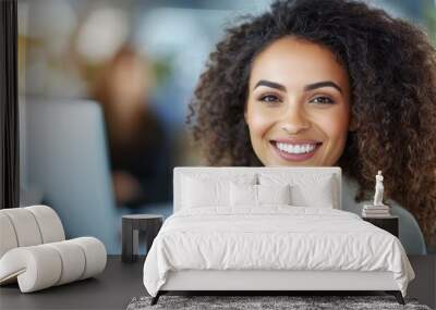 A woman with curly hair is smiling at the camera Wall mural