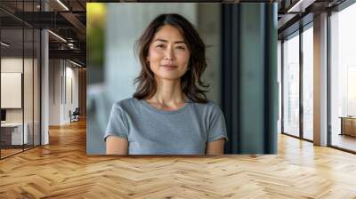 A woman with long hair and a gray shirt is smiling Wall mural