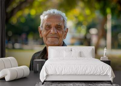 An older man with a smile on his face is standing in a park Wall mural