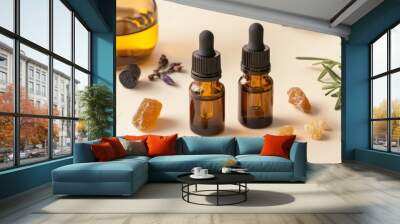 Two bottles of essential oils are on a table with some herbs and rocks Wall mural