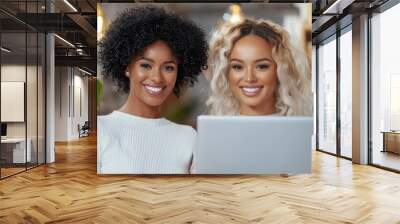 Two women with curly hair are smiling and looking at a laptop Wall mural