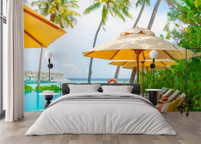 Umbrella and chair around swimming pool in resort hotel Wall mural