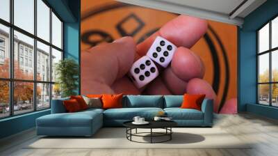 A hand shows two six-sided dice showing Double Six with black dots. Person holds two dice displaying lucky combination numbers during a backgammon game. Wall mural