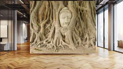 Head of sandstone buddha in the bodhi tree roots Wall mural