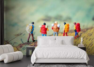 Miniature people: Group of backpacker on vintage world map using as business trip traveler adviser agency or explorer on earth background concept. Wall mural