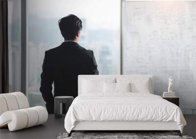 A businessman standing in an office room with a whiteboard. Company business plan strategy idea thinking. Wall mural