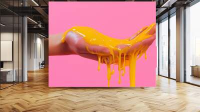  a human hand dripping glue on a pink background in Wall mural