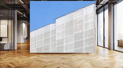 Plastic cloth covering tall buildings during construction Wall mural