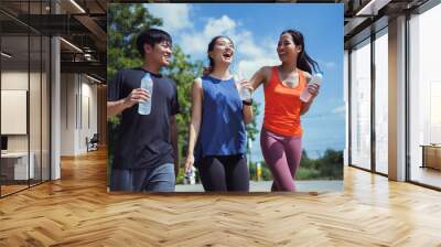 Asian friends group jogging in the morning They have talk and drink water. Wall mural