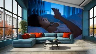 asian women are using the smart phone on the bed before she slee Wall mural